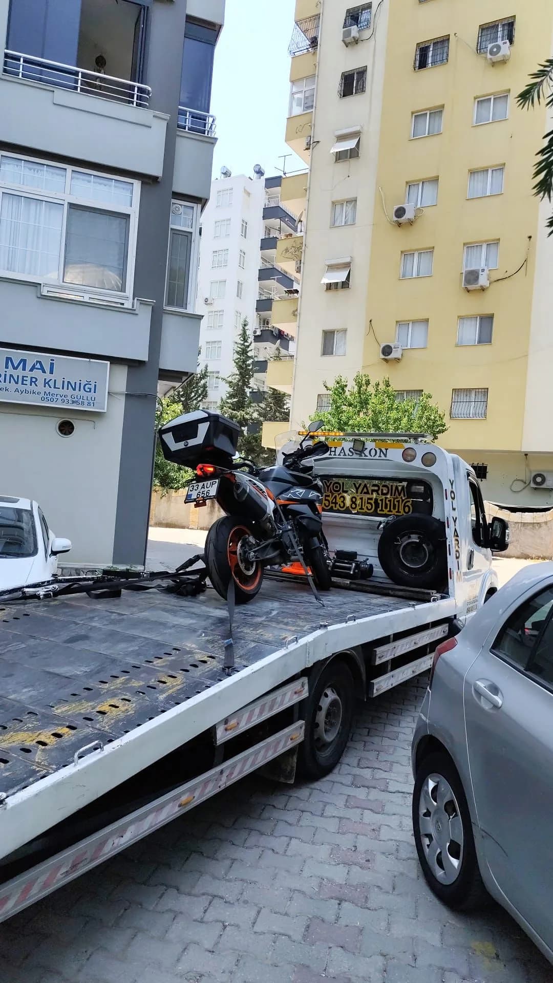 Bağlama kayışlarıyla çekici platformuna sabitlenmiş motosiklet